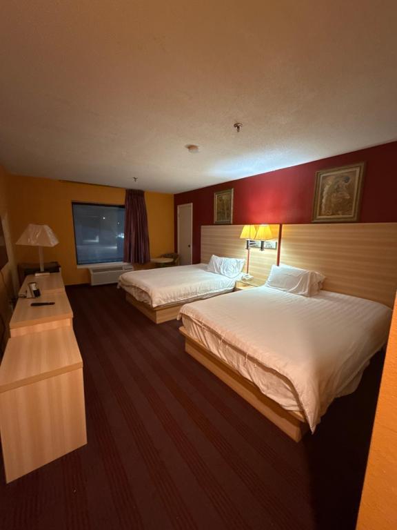ein Hotelzimmer mit zwei Betten und einem Fernseher in der Unterkunft Ashburn inn in Manning