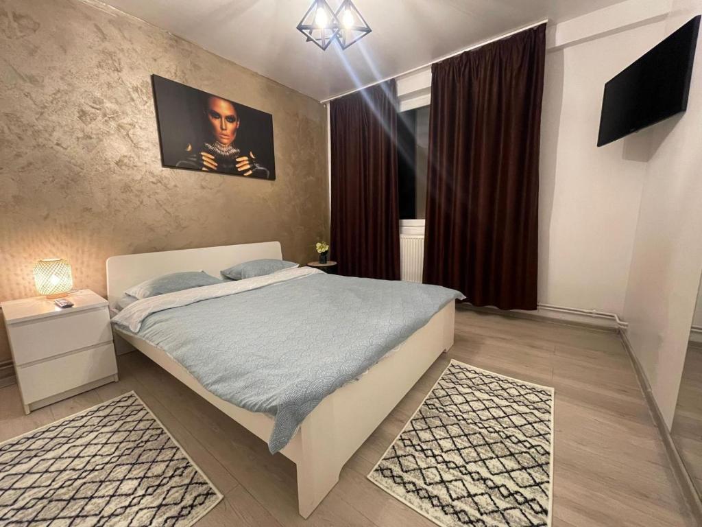 ein Schlafzimmer mit einem Bett und einem Fernseher darin in der Unterkunft LCB Apartments P Victoriei in Ploieşti