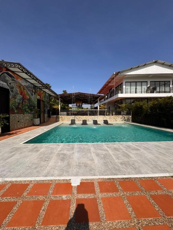 a shadow of a person standing in front of a swimming pool at Hotel Campestre Alma Nativa in Calarcá