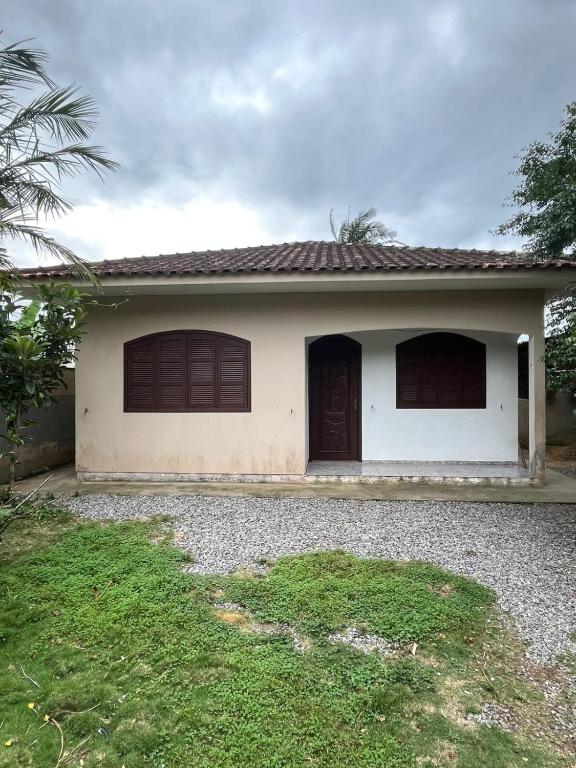 una pequeña casa blanca con garaje en Ampla casa em Porto Belo com fácil acesso à Zimbros, en Porto Belo