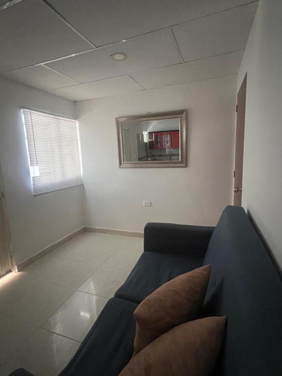 a living room with a couch and a mirror at Aparta estudio Santa Marta in Santa Marta