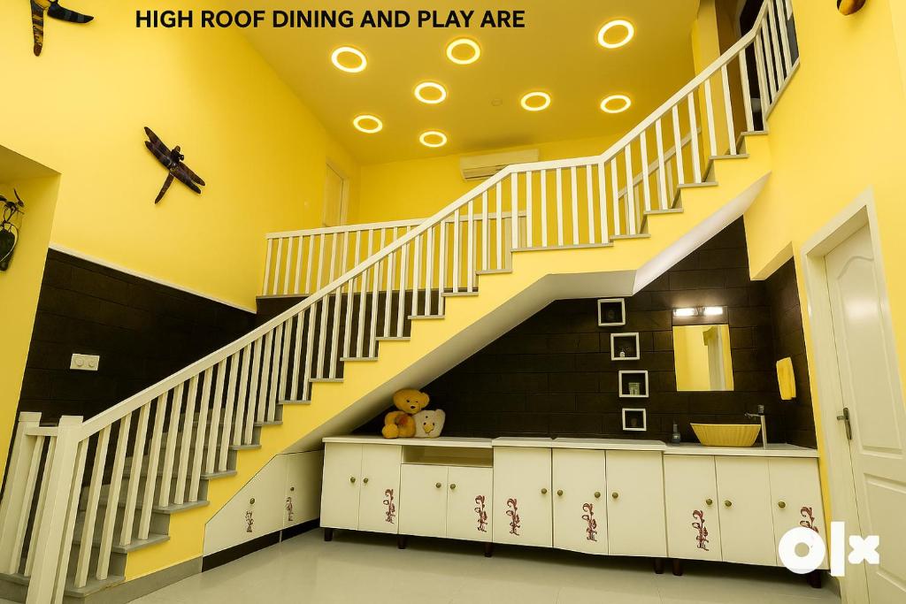 a staircase in a room with yellow walls at Charis Villa and Guest house 5bed 4bath in kunnamkulam in Kunnamkulam