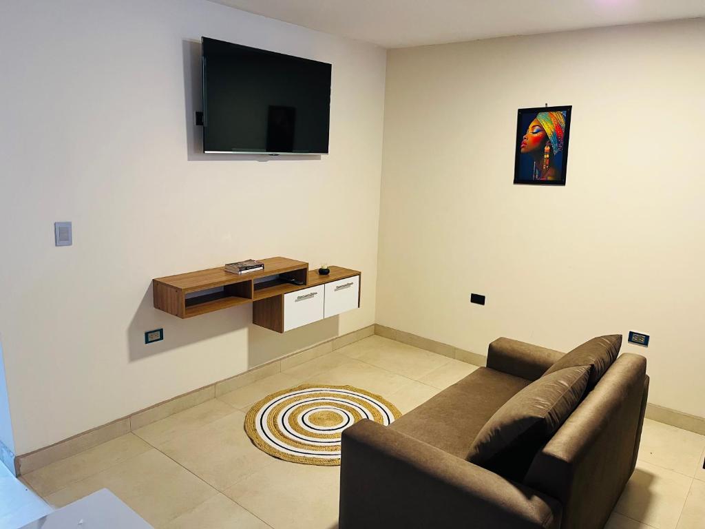 a living room with a couch and a flat screen tv at Suite in Ibarra