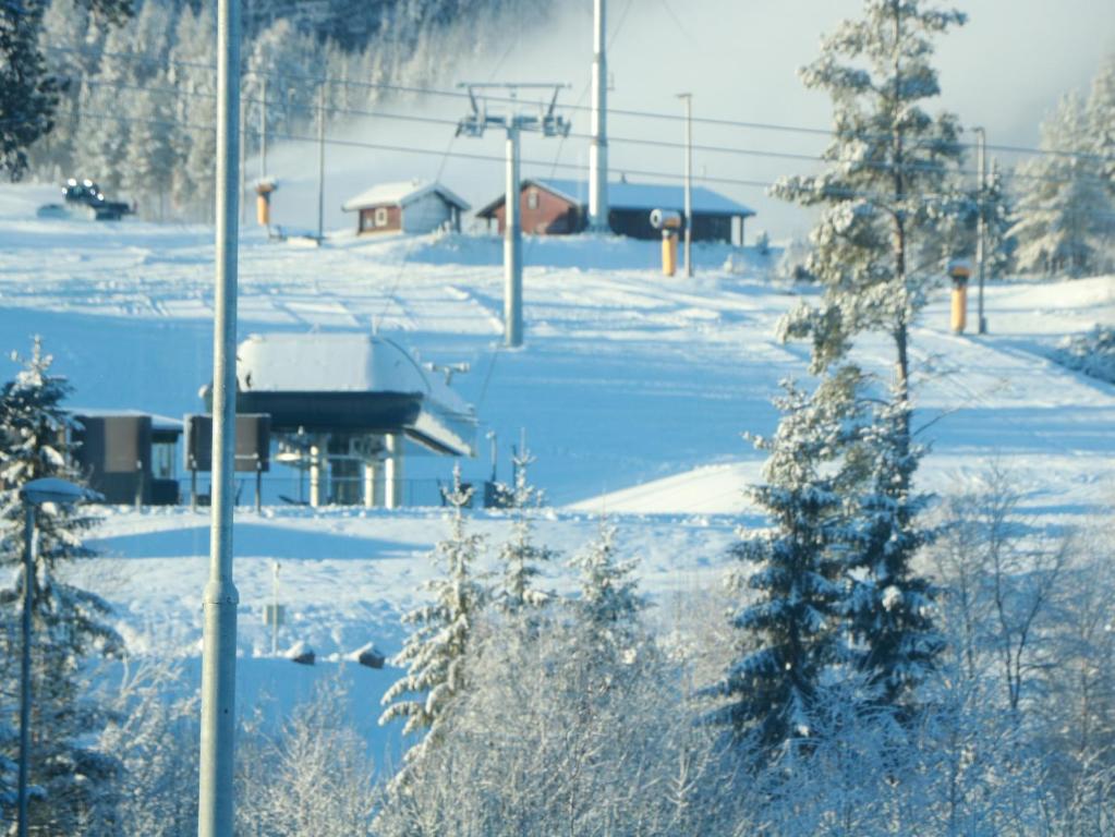 un campo cubierto de nieve con un remonte a lo lejos en Trysil turistesenter hytte, en Trysil