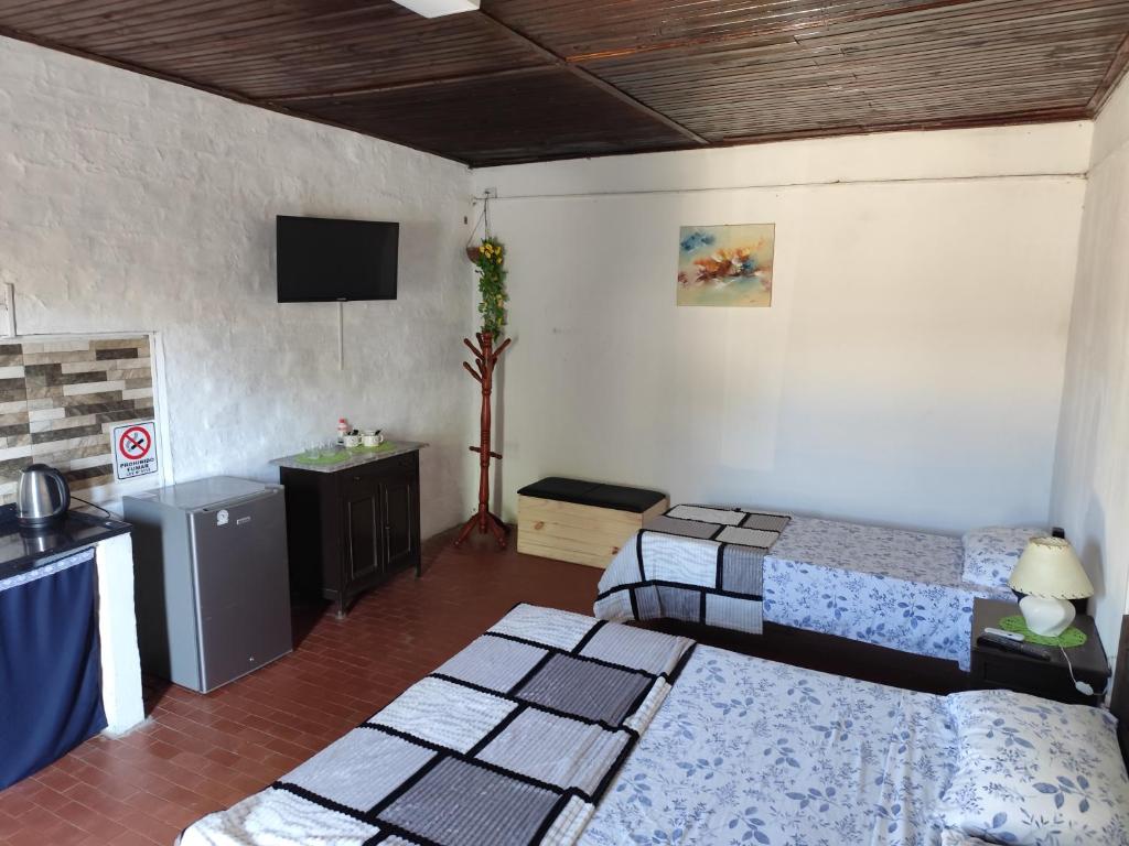 un soggiorno con 2 letti e una TV di Ruma a Bella Unión