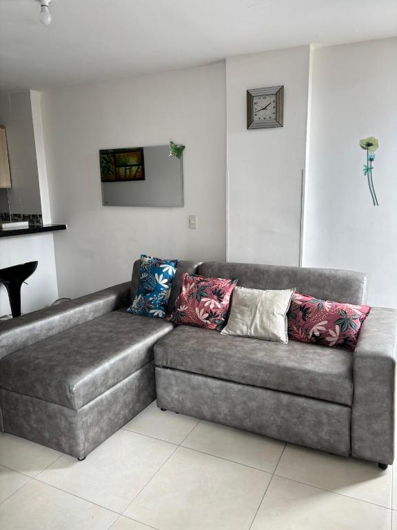 a couch with pillows on it in a living room at La Morada del Sur in Floridablanca