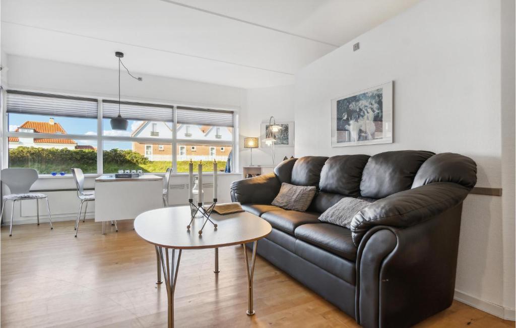 een woonkamer met een leren bank en een tafel bij Fanø Bad, Lejl 12 in Fanø