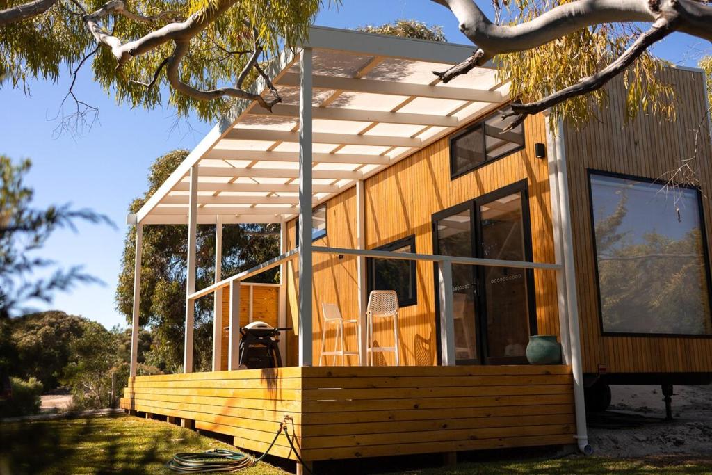 a house with a wooden porch with a pergola at Whittle Home - NEW TINY HOME in Robe
