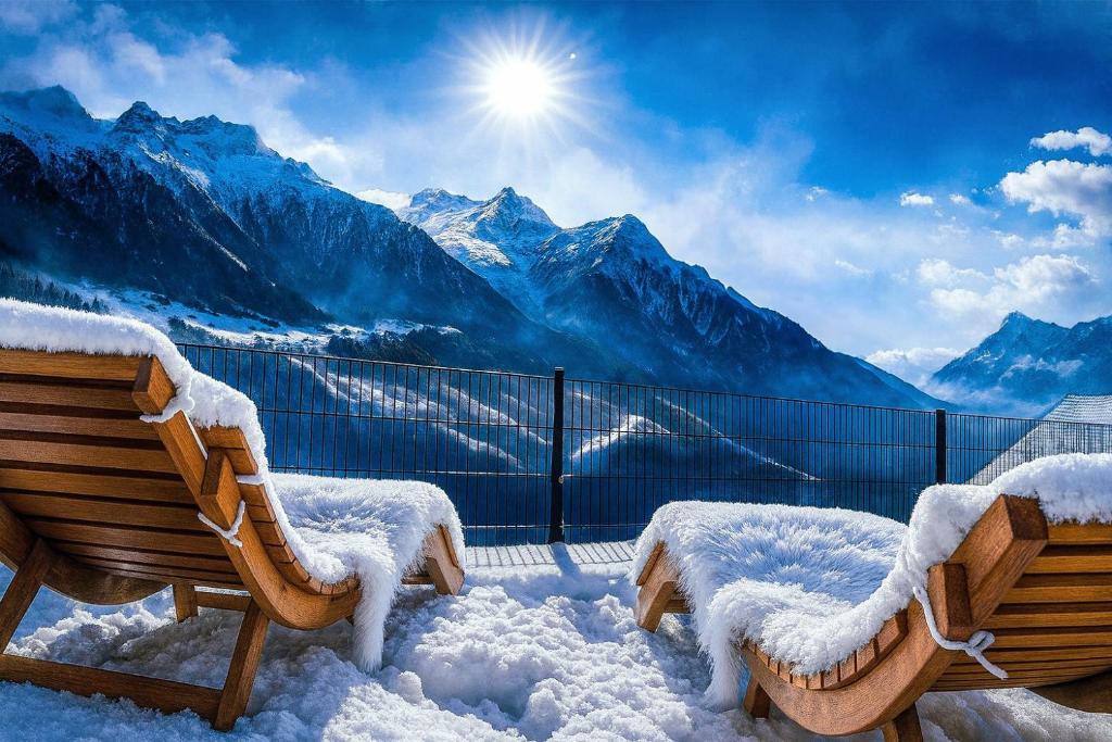 two benches on a balcony with snow covered mountains at Mattertal Lodge in Embd