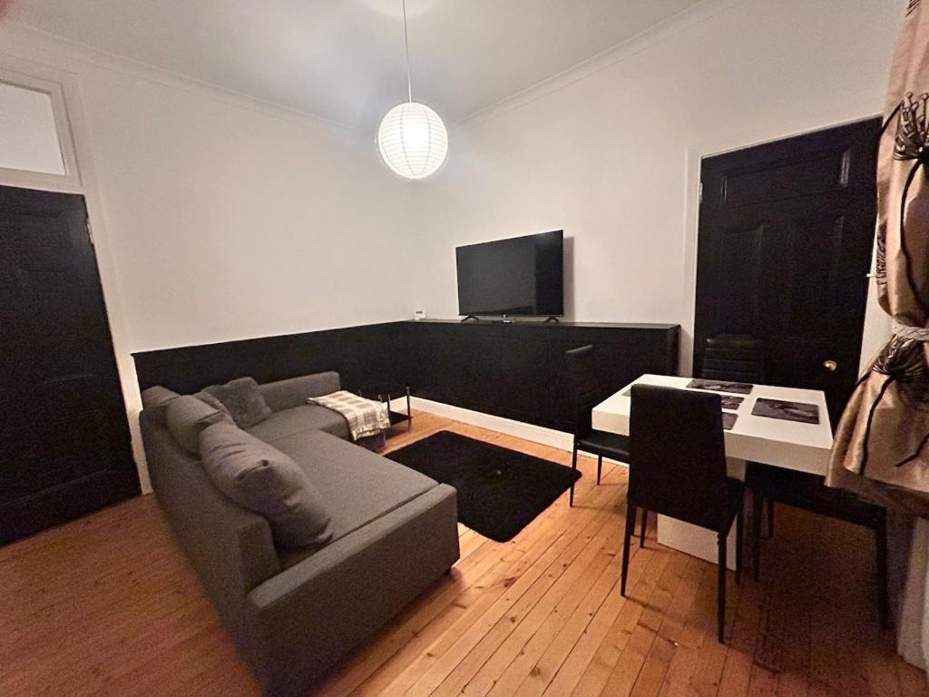 a living room with a couch and a table at Blackthorn Manor in Greenock