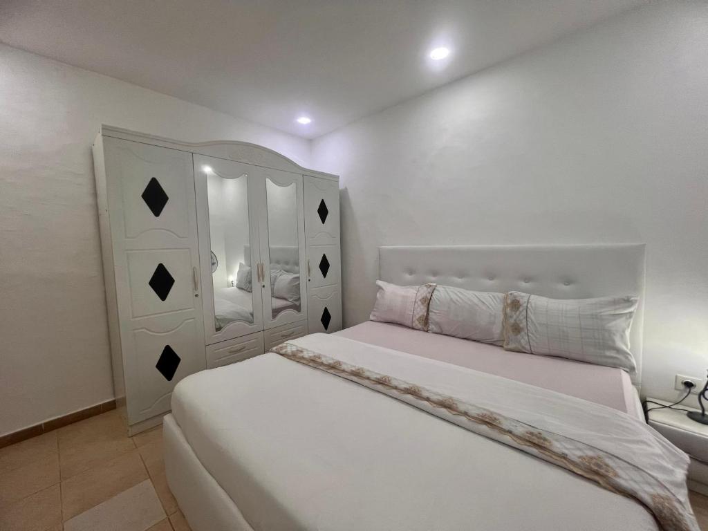 a bedroom with a white bed with a white headboard at JOLIE CHAMBRE moderne toilette partagé a yoff virage N3 in Dakar