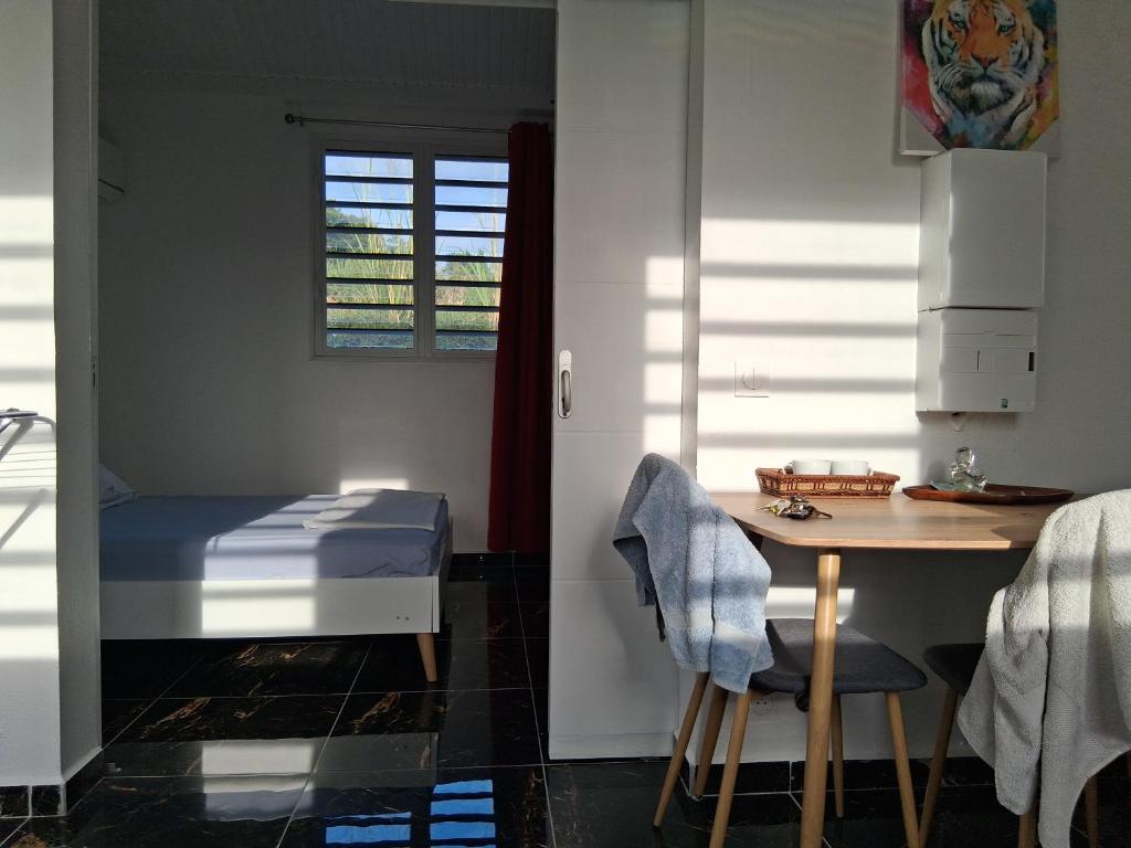 a room with a bed and a table and a desk at Kaz o ti plezi in Sainte-Rose
