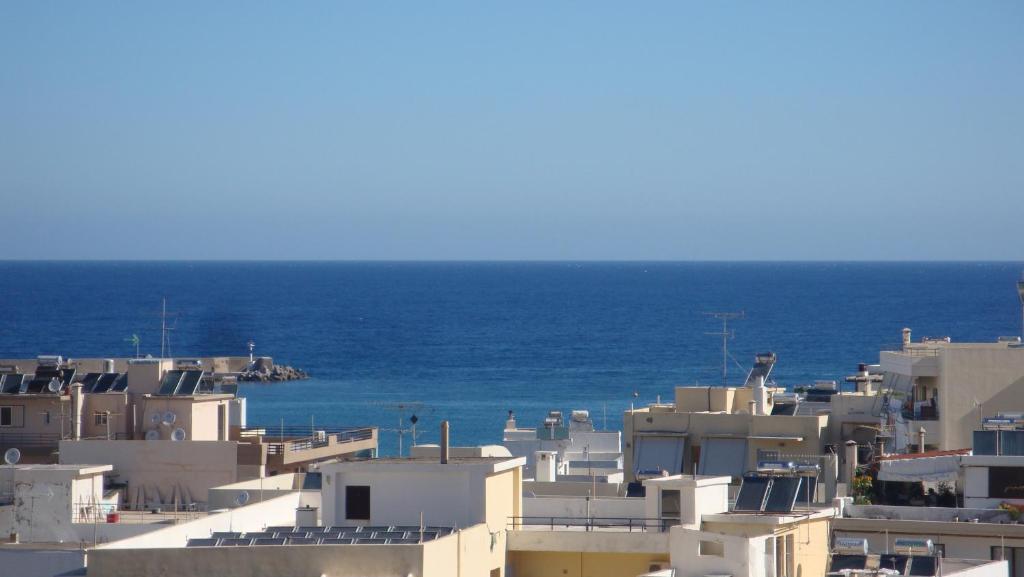 Eine Gruppe weißer Gebäude vor dem Hintergrund des Ozeans in der Unterkunft Brillarooms in Rethymno
