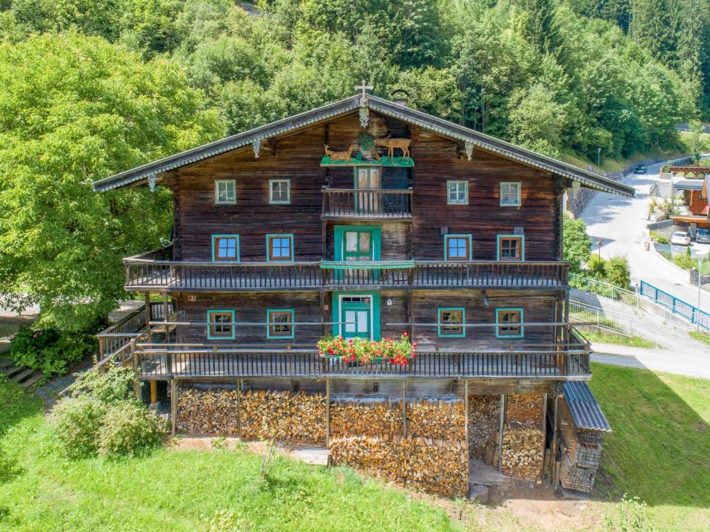 an old log house with flowers in the window at Alte Grafenmühle in Hopfgarten im Brixental