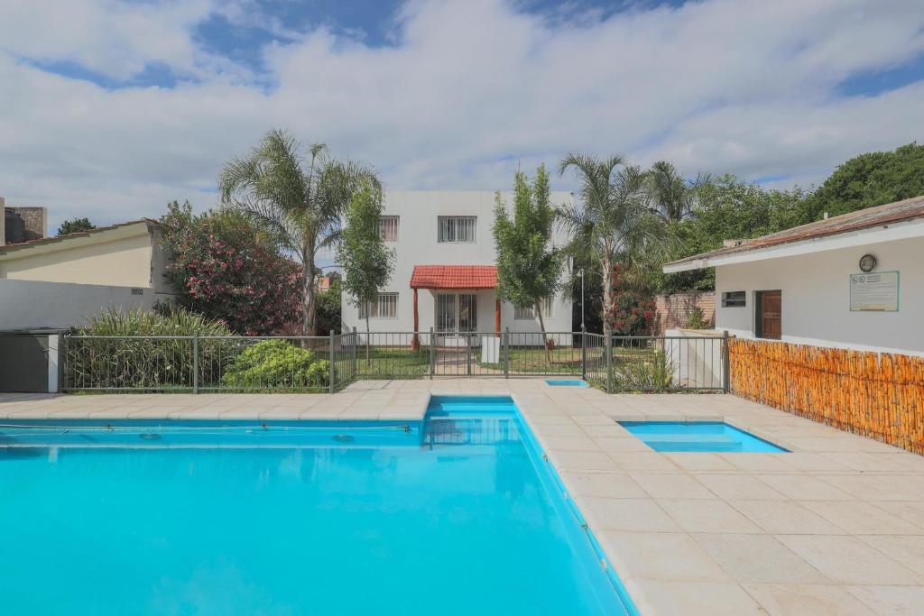 a swimming pool in front of a house at Posada D`Lua in Villa Carlos Paz