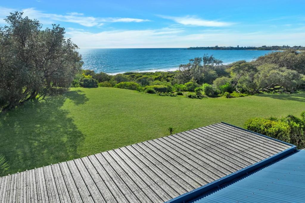 an aerial view of a field and the ocean at Surfbreak, Culburra Beach in Culburra Beach