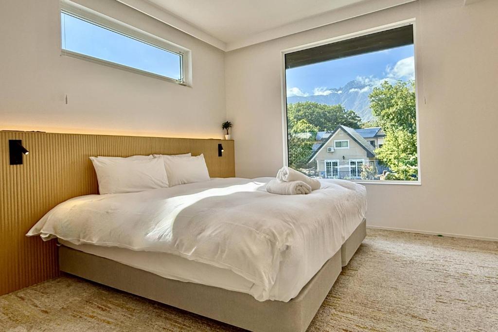 Un dormitorio con una cama grande con una ventana grande. en Vive Boutique Hotel - Echoland, en Hakuba