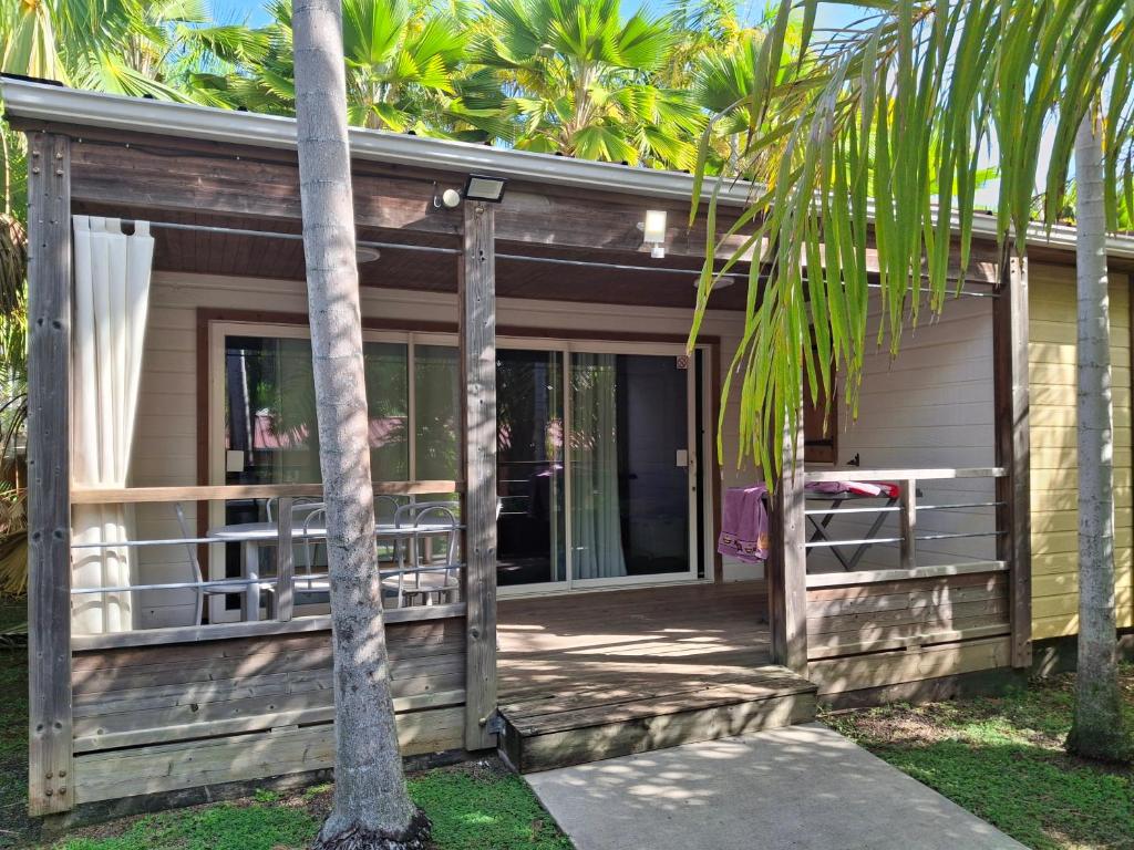 a house with a porch with palm trees at Le Cottage 61 - Au Bonheur de Sophie in Le Vauclin