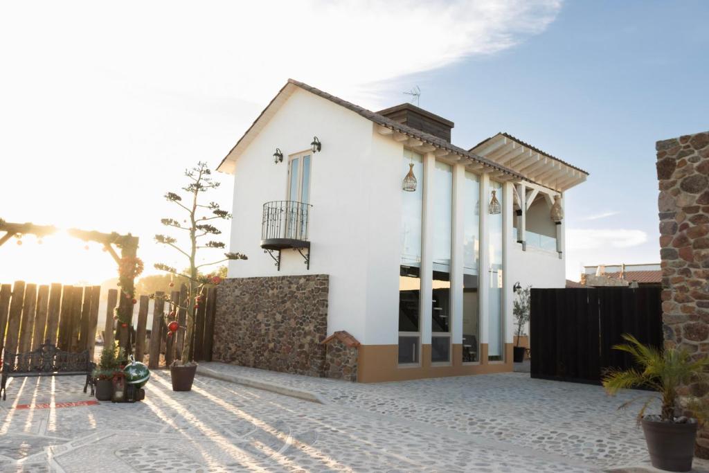 a white house with a fence in front of it at Cabañas San Antonio in Ezequiel Montes