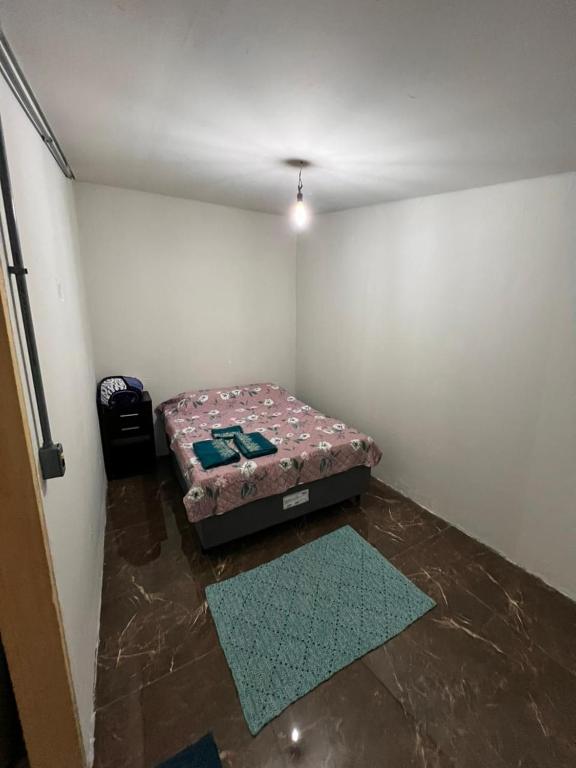 um pequeno quarto com uma cama no canto em Casa próximo a UFR - QUARTO SALA E COZINHA EQUIPADA em Rondonópolis