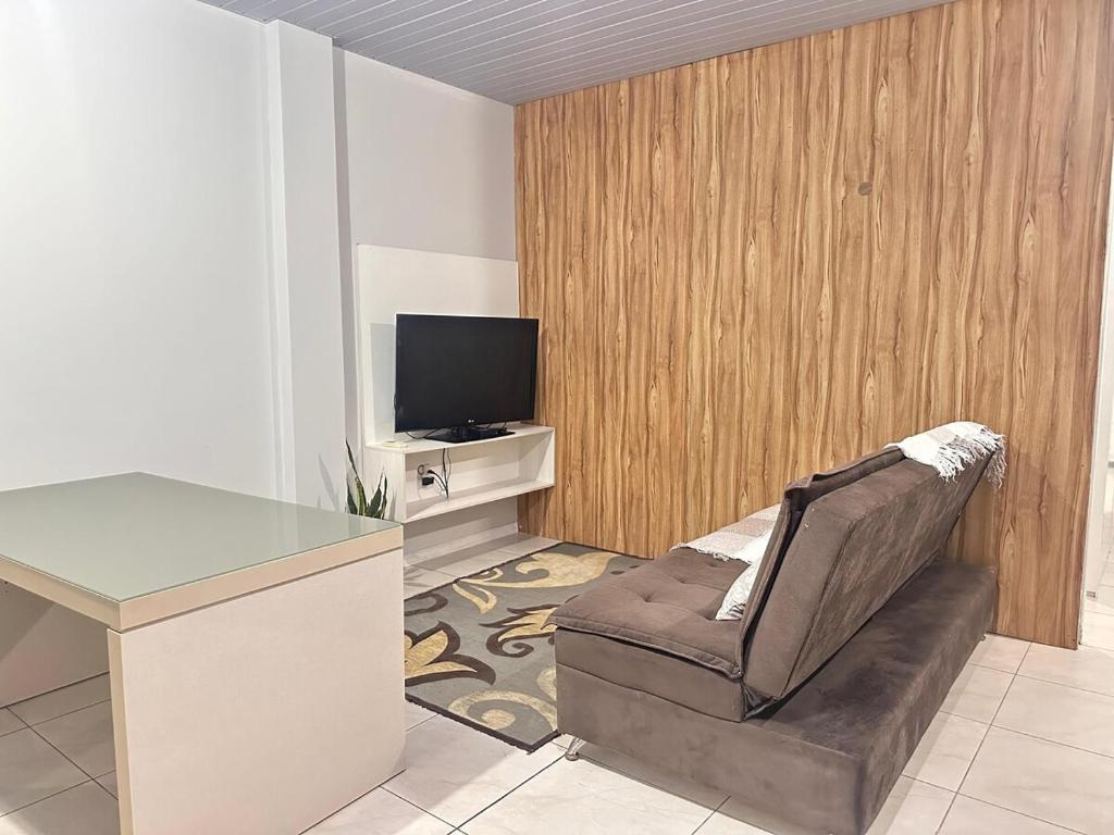 a office with a chair and a desk and a television at Casa com 02 Quartos em Balneário Camboriú in Balneário Camboriú