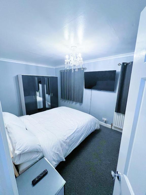 a bedroom with a white bed and a chandelier at Mona in Hull