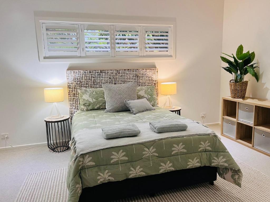 a bedroom with a large bed with two lamps at Oasis by the Bay - 4 bedroom Beach House in Corlette