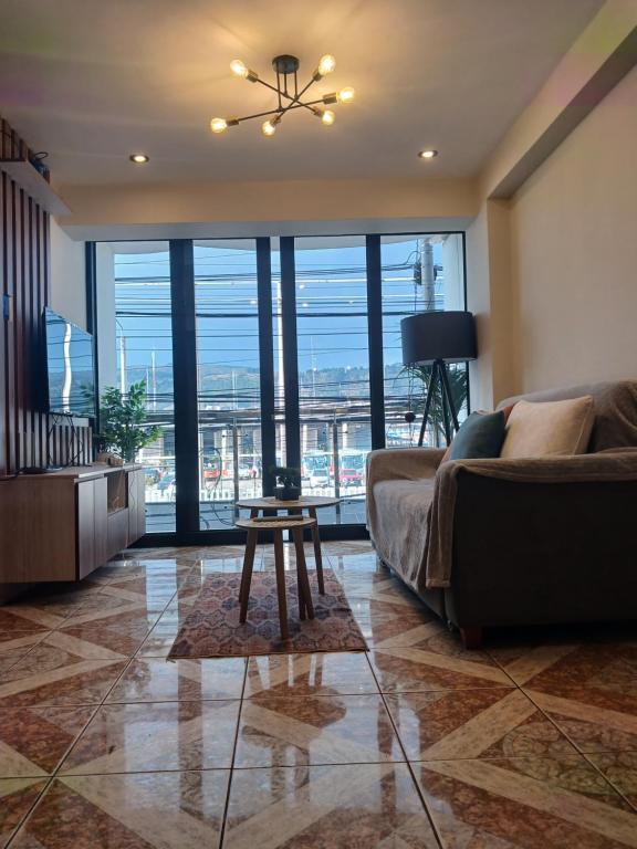 a living room with a couch and a table at Qosqo Air Loft in Cusco