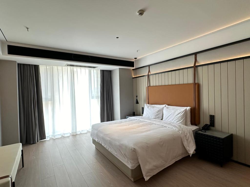 a bedroom with a large bed and a large window at FunGeeX in Datong