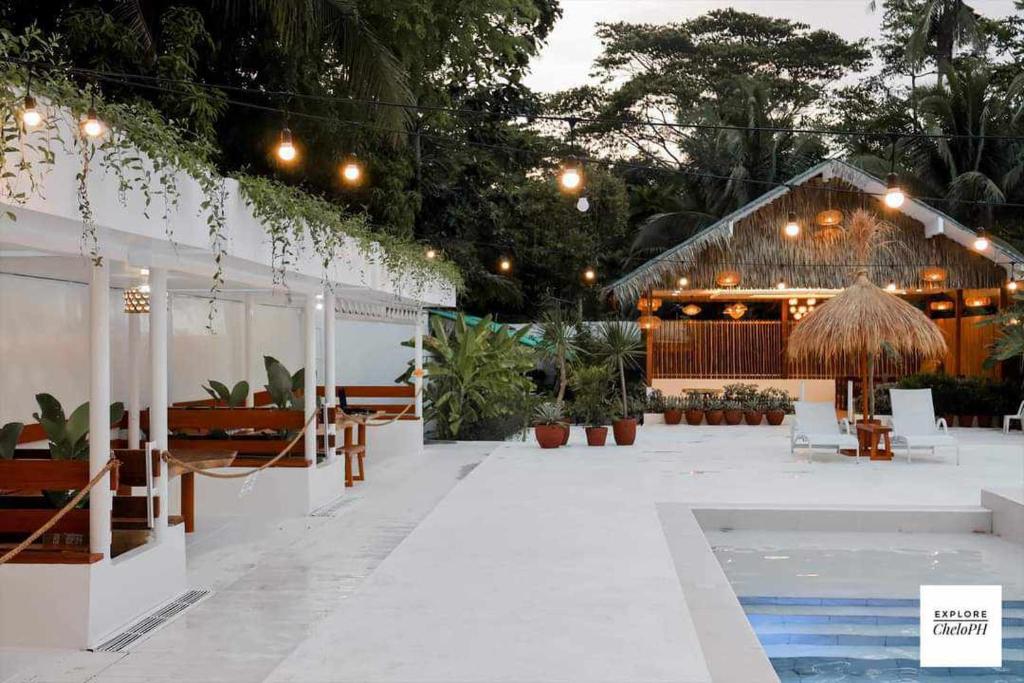 eine Terrasse mit Pool und ein Haus mit Beleuchtung in der Unterkunft Villa Soledad Garden Resort in Sampong