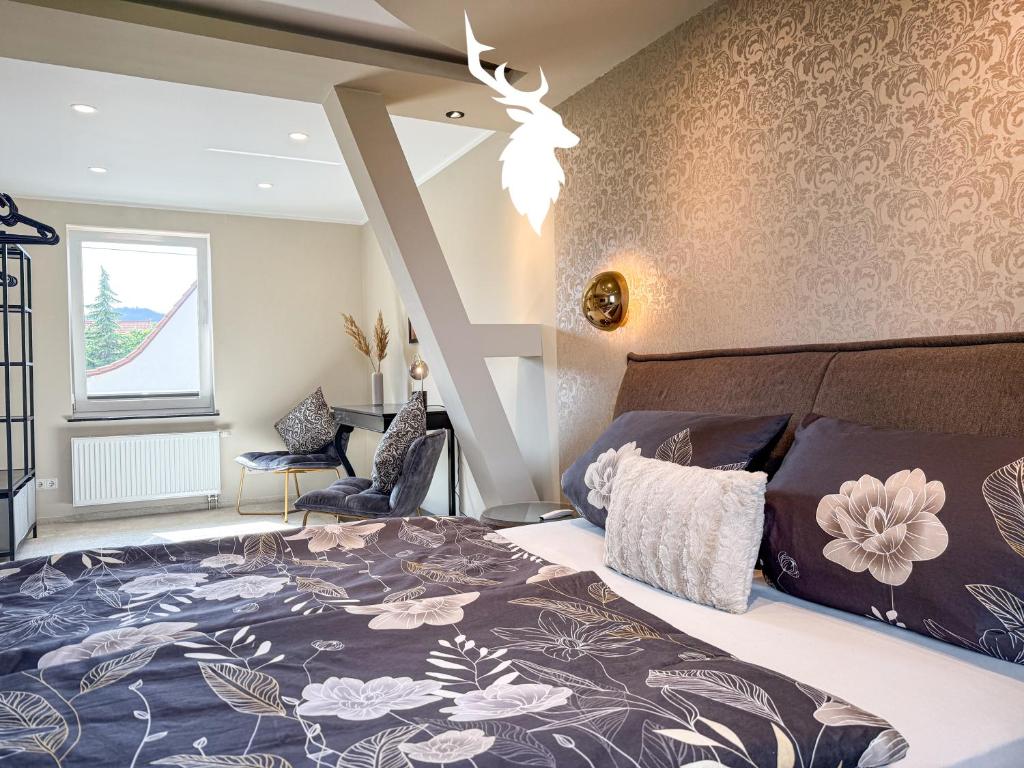 Un dormitorio con una cama grande con una pared con estampado de flores. en WILD&COZY Ferienhaus mit luxuriöser Küche & Garage, en Blankenburg