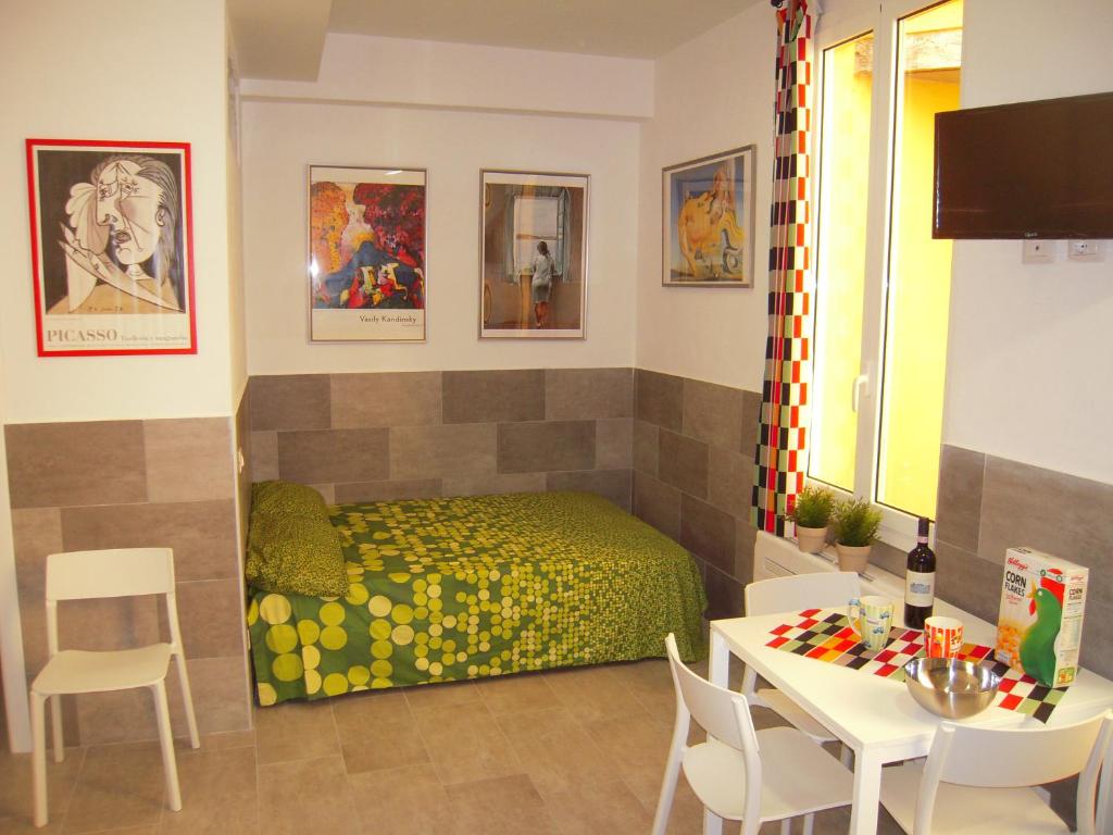 1 dormitorio con 1 cama, mesa y sillas en Bolognahome, en Bolonia