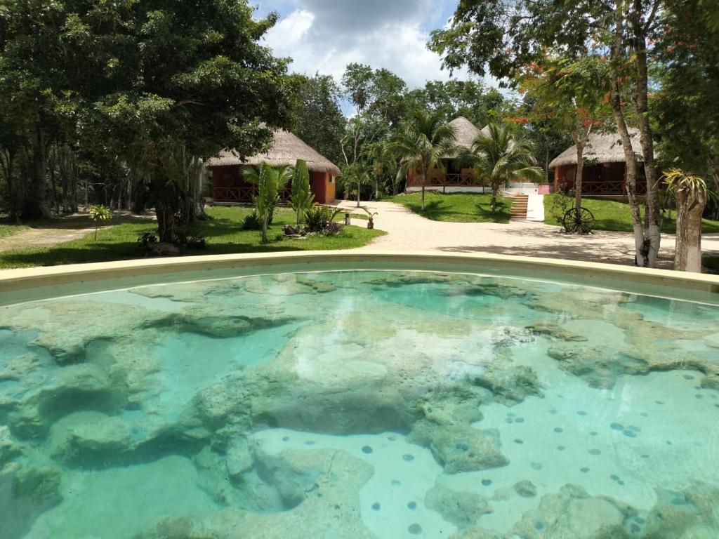 a swimming pool in front of a house at Hotel Aldea Cruzo'ob in Felipe Carrillo Puerto