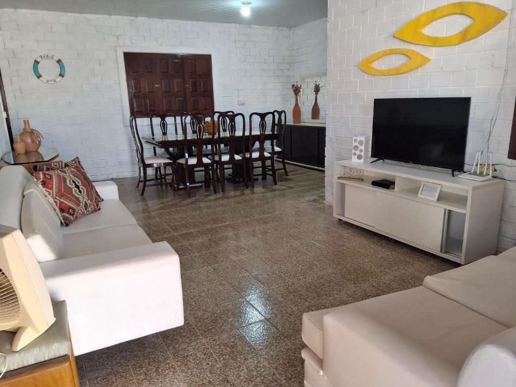 ein Wohnzimmer mit weißen Möbeln und einem Flachbild-TV in der Unterkunft Casa de Veraneio com 4 quartos in Barra de São Miguel