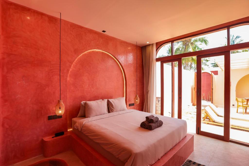 ein Schlafzimmer mit einem Bett und einem großen Fenster in der Unterkunft Villa Solea in Gili Trawangan