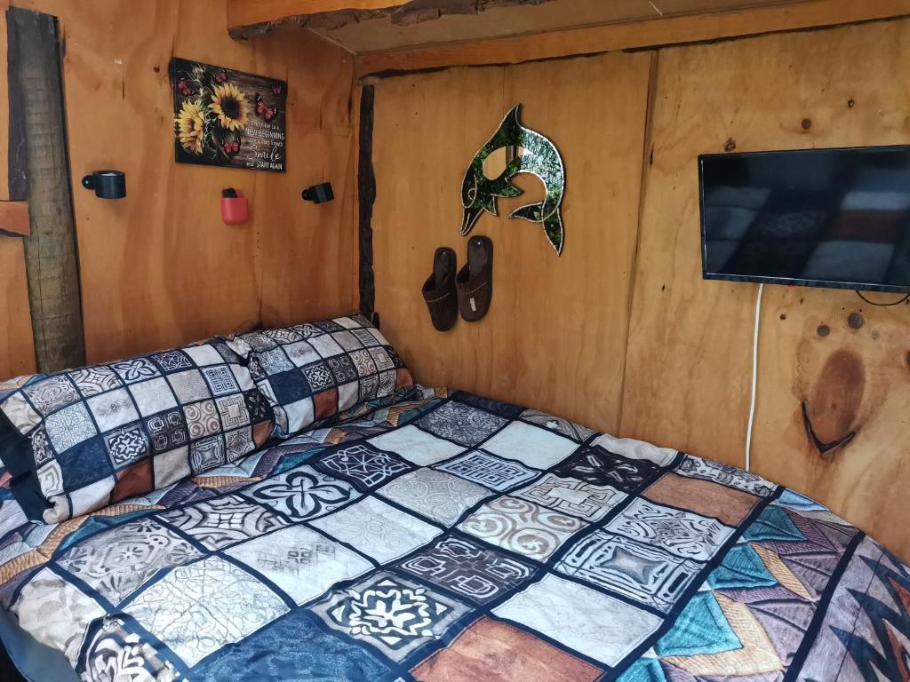 una camera da letto con un letto e una TV di The Abel Tasman Treehouse a Marahau