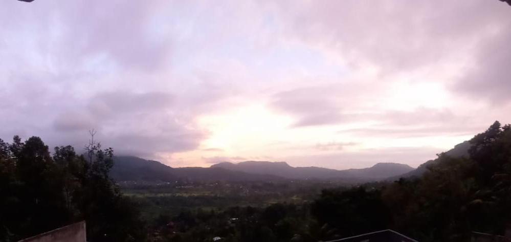 een bewolkte lucht met bergen in de verte bij Rumah Bagus Jayanti in Sidemen