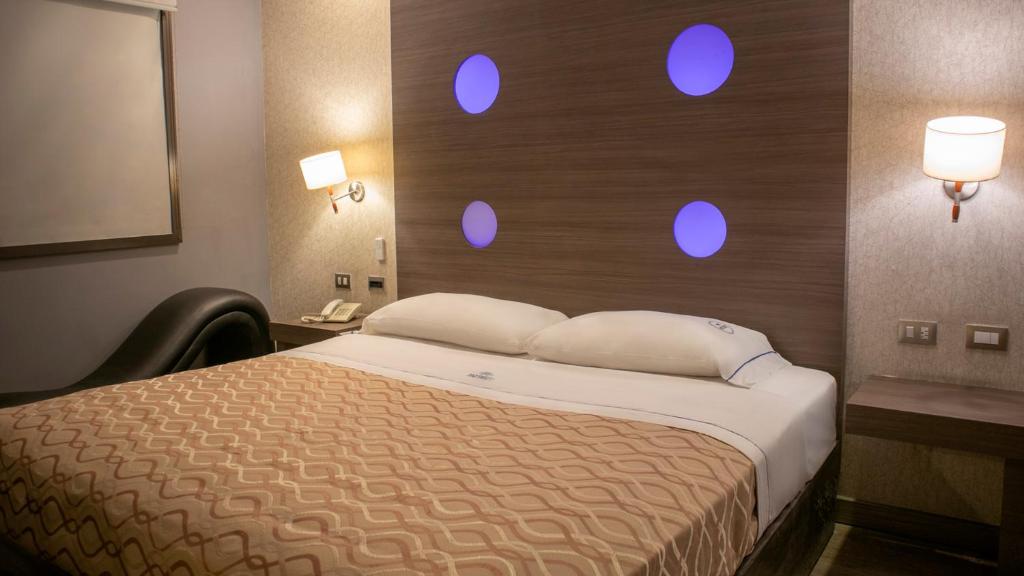 a bedroom with a bed with blue lights on the wall at Hotel Muy Cdmx, Love Hotel in Mexico City