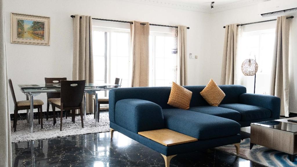 a living room with a blue couch and a table at Nkrabea Royal Apartment in Trofwi