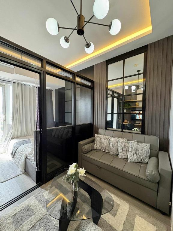 a living room with a couch and a bed at Cozy Sunset Condo Thompson Stay in Manila