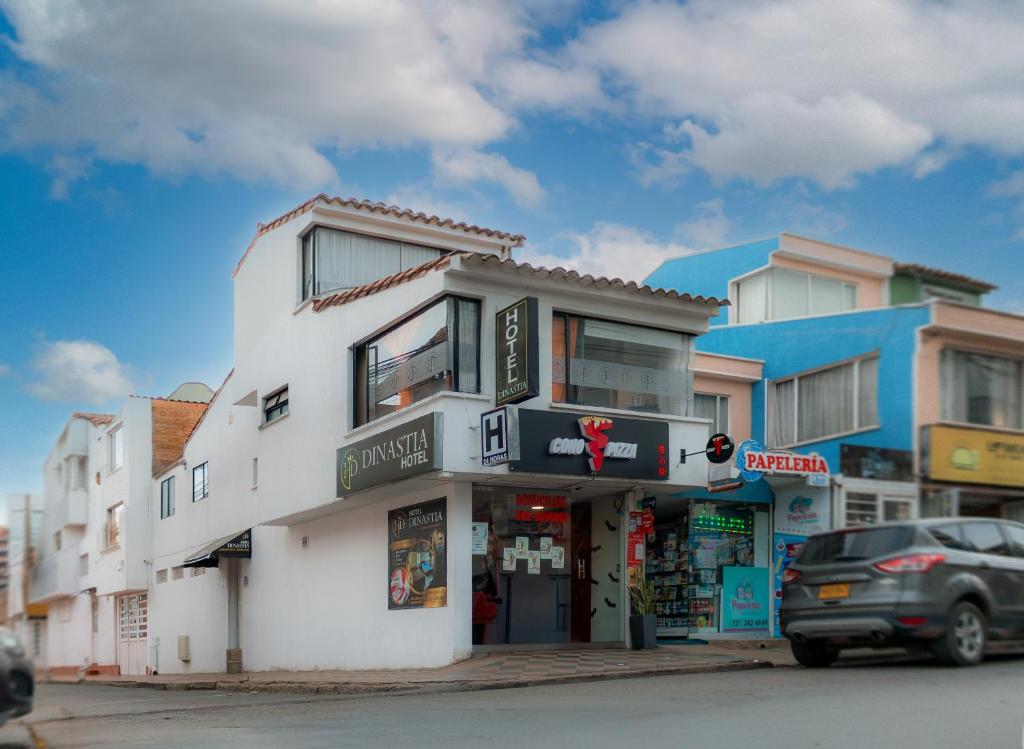 a white building on the side of a street at hotel Dinastia in Tunja