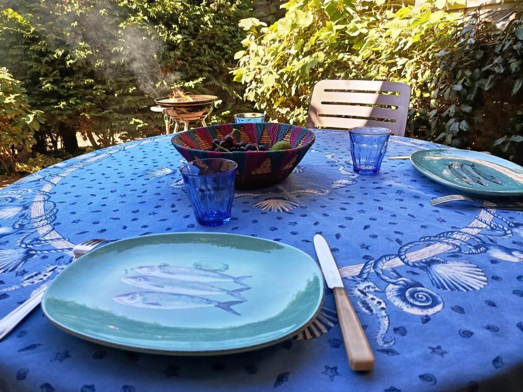 a blue table with plates and a bowl of fruit on it at Villa T2 Mezzanine, 5 pers, à 600m de la plage. Animaux admis. - FR-1-793-36 in Saint Cyprien Plage