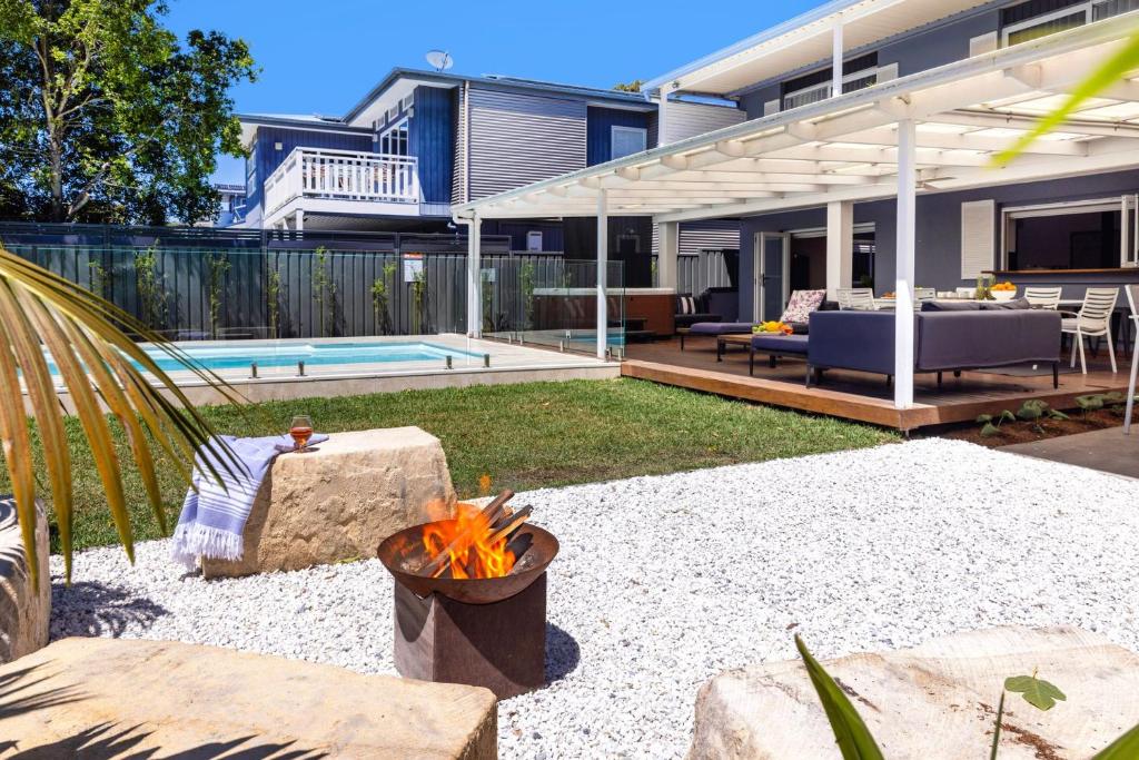 a backyard with a fire pit and a house at 35 South - Pet Friendly Beach House with Pool, Spa in Vincentia