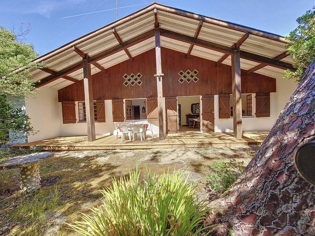 莫列马阿Villa pour 6 pers à Moliets avec animaux admis - FR-1-857-28的大型木屋配有桌椅