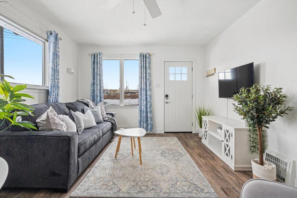 un soggiorno con un divano e un tavolo di Blue Raptor Family-Friendly 3BR Private Yard a Drumheller