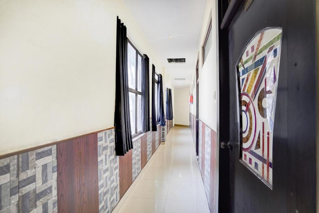 a hallway with paintings on the walls and a door at Collection O Jhalwar Road in Kota