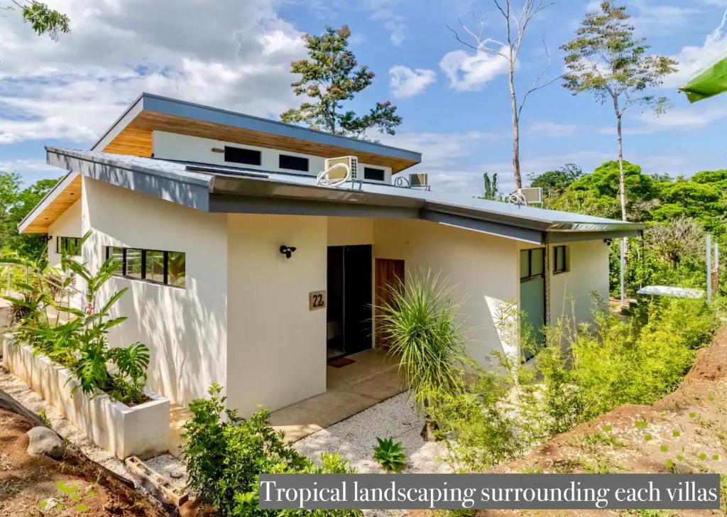 ein kleines weißes Haus mit blauem Dach in der Unterkunft Reserva Atmosfëre in Upala