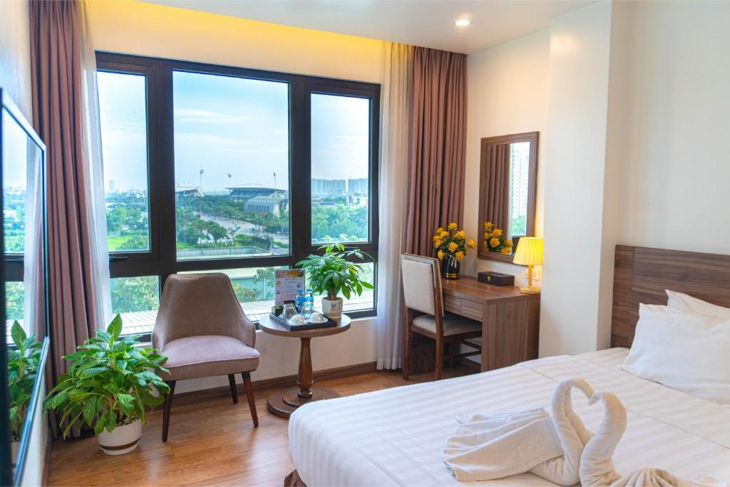 河内A89 Premier Sky Residence Stadium View的一间带床、书桌和窗户的酒店房间