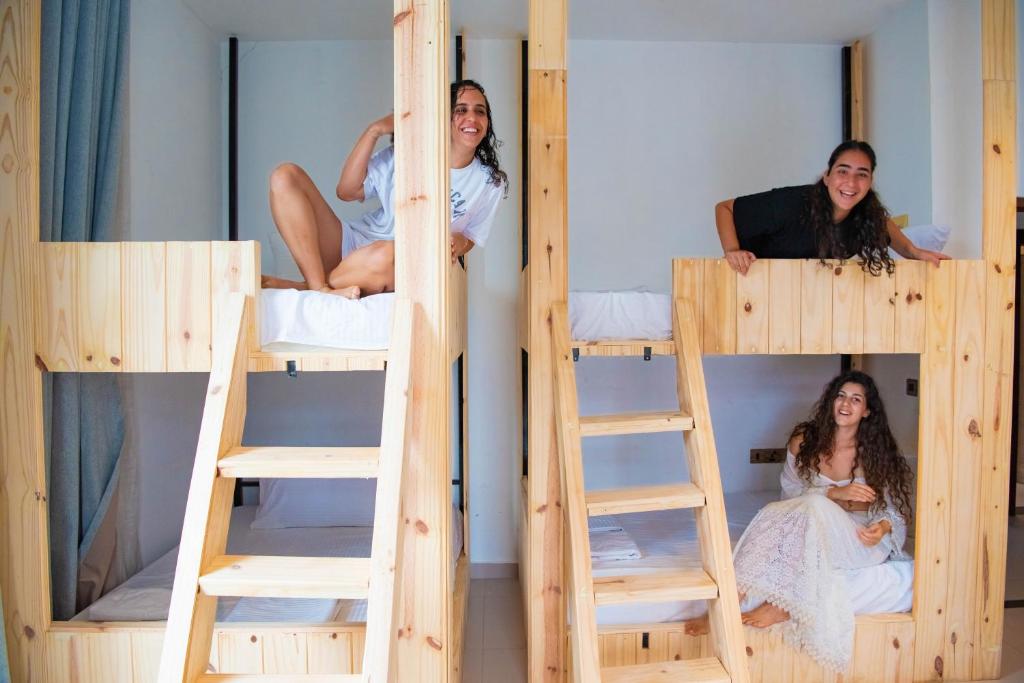 a group of three girls sitting in bunk beds at Elements Hostel And Coworking in Weligama