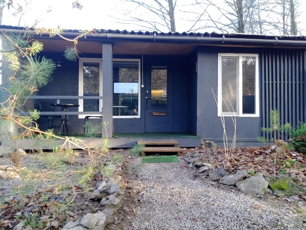 a small house with a blue door and windows at Scandinavia bungalow in Kamennaya Gora